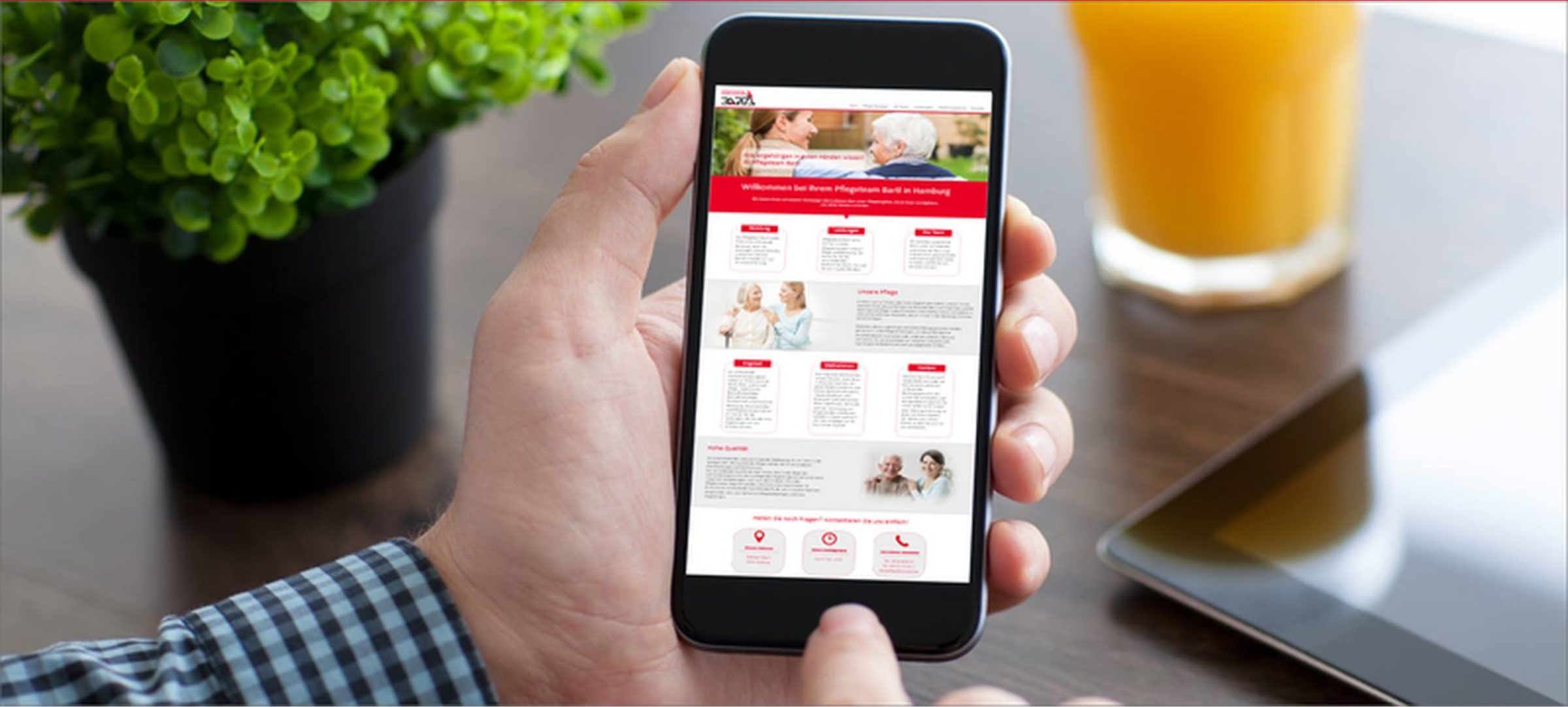 Hand hält ein Smartphone mit der Website von Pflegedienst Bartl