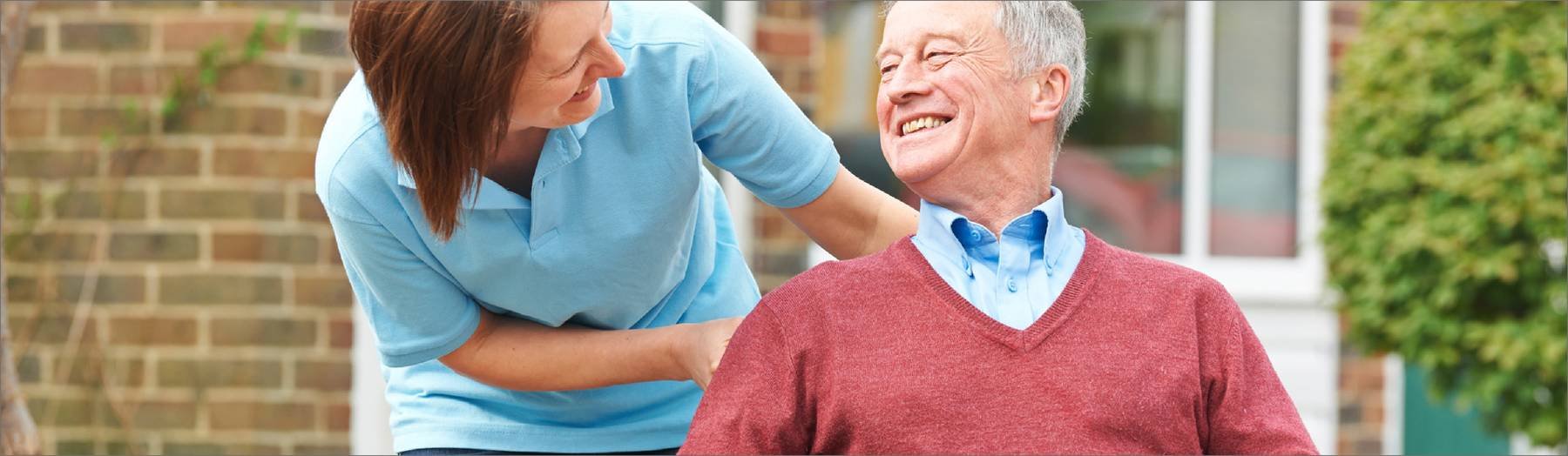 Pflegekraft mit Senior im Rollstuhl